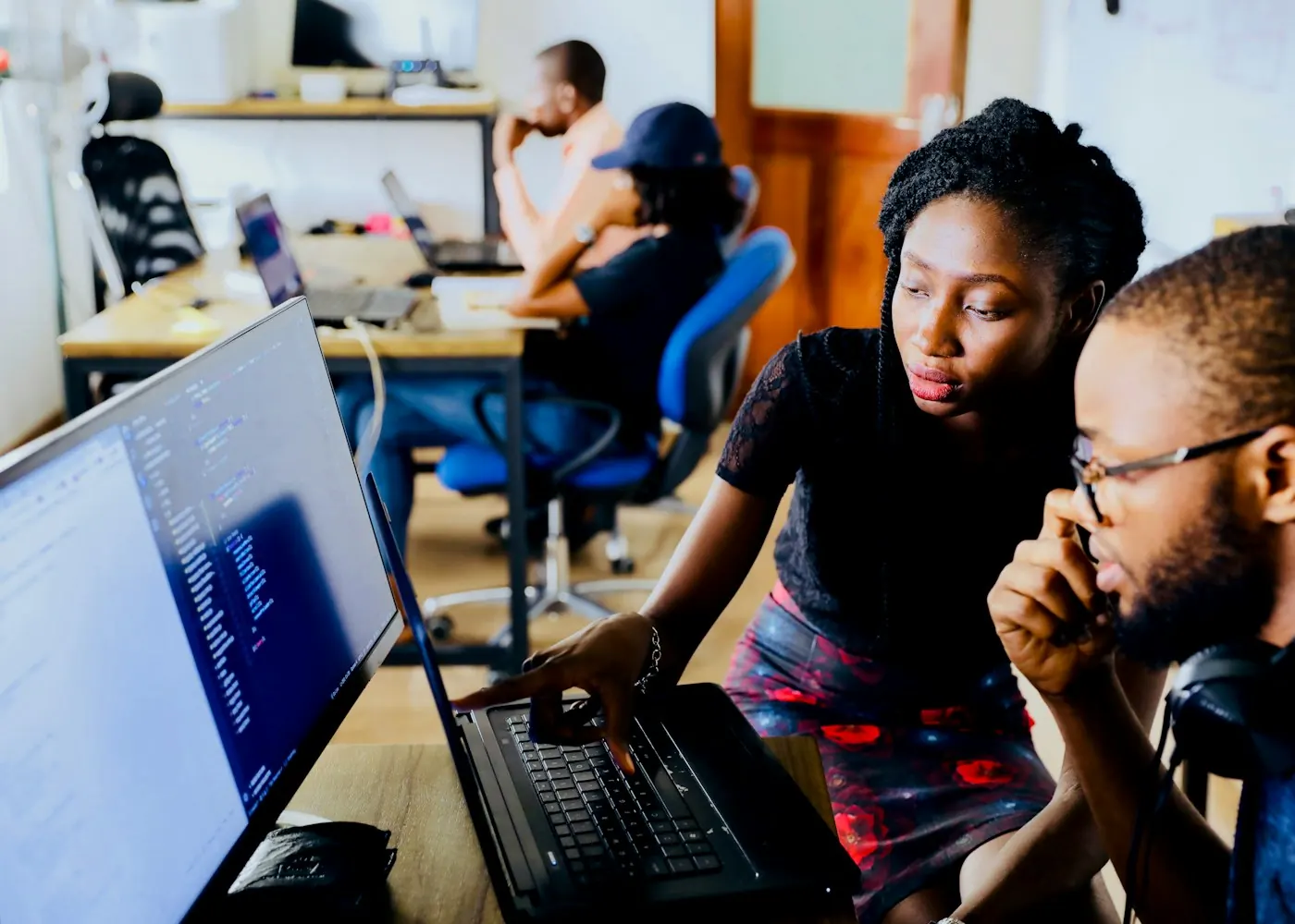 Two colleagues reviewing work together on a laptop